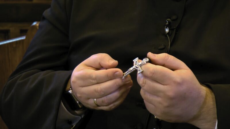 How Catholics Pray to Saints in the Daily Life. A Bishop Holding a Rosary