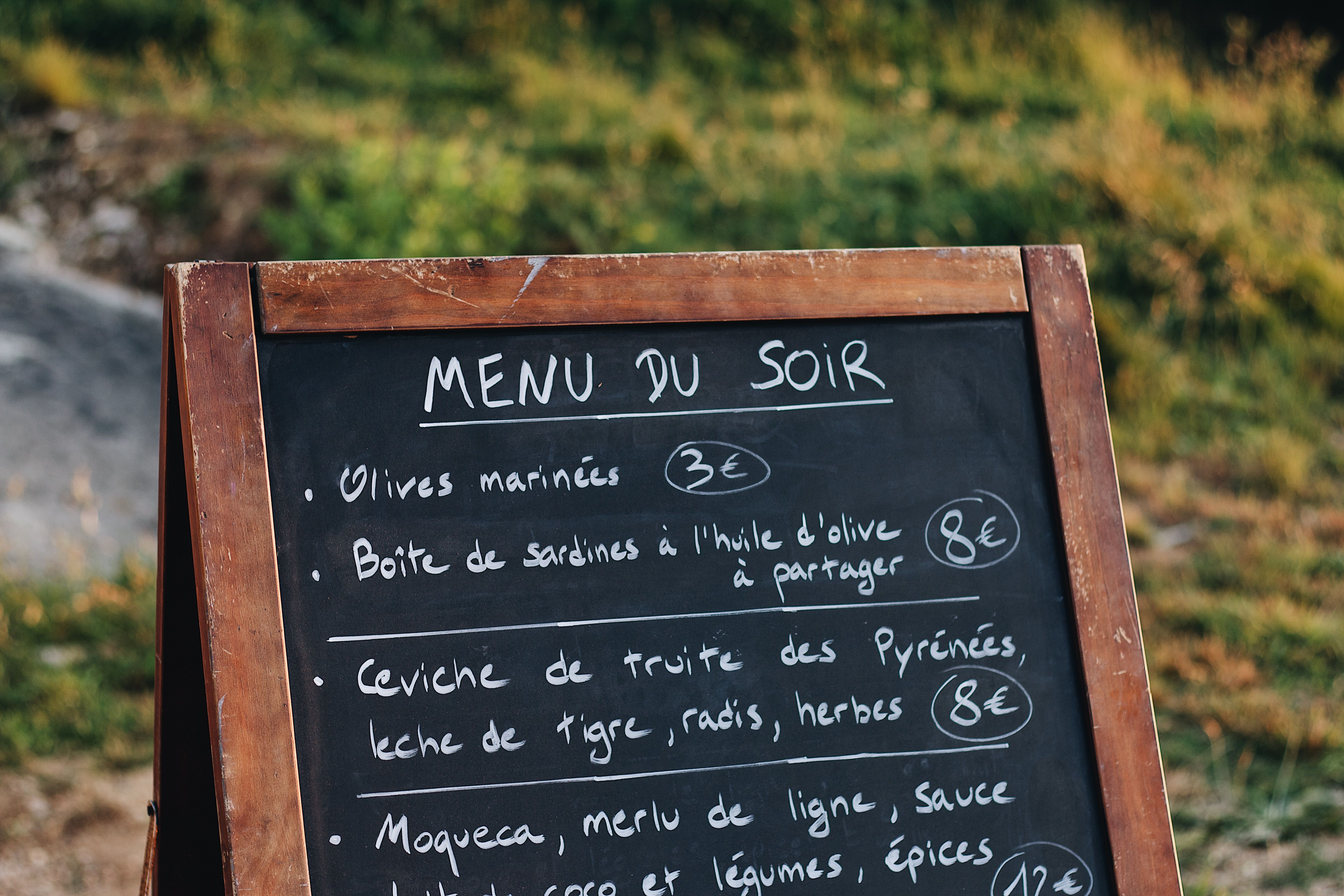 Chalkboard menu displaying dishes and prices, an example of an inviting event menu sign.
