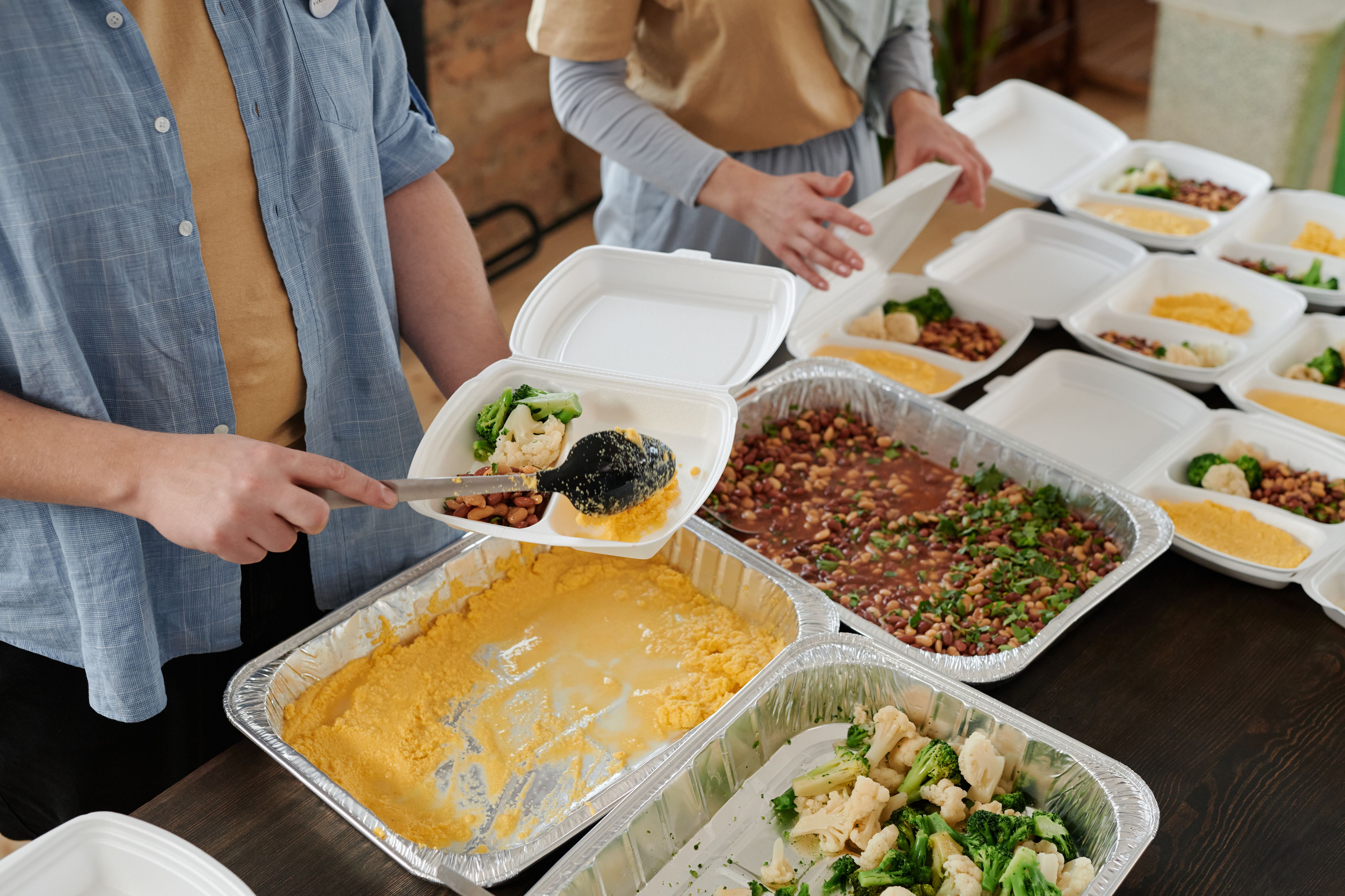 Volunteers preparing food packs for donation, representing the service-centered purpose of a faith fundraiser.