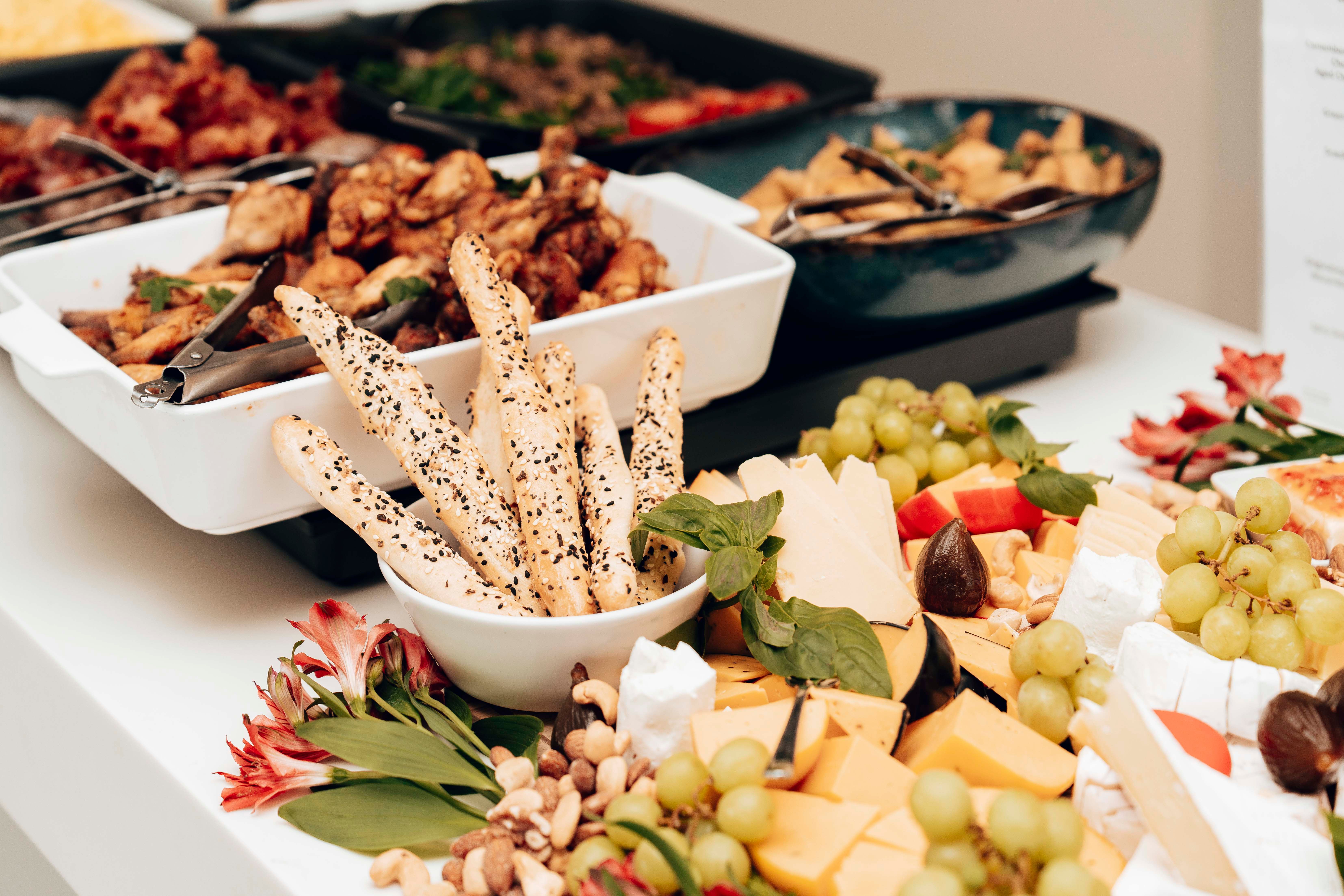 Cheese, breadsticks, and fruit arranged on a buffet table for a flexible grazing-style menu.